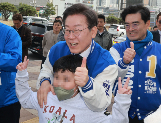 지난 3월17일 이재명 더불어민주당 대표가 경기 화성시 동탄호수공원 인근에서 아이들과 기념촬영을 하고 있다.<연합뉴스 사진>